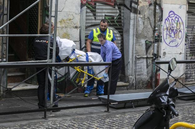 Trabajadores de la funeraria y emergencias trasladan el cadáver del hombre fallecido. 