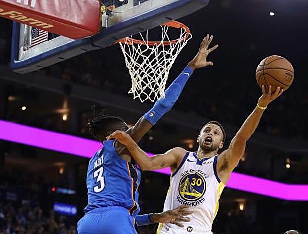 Stephen Curry entra a canasta con la oposición de Nerlens Noel. 