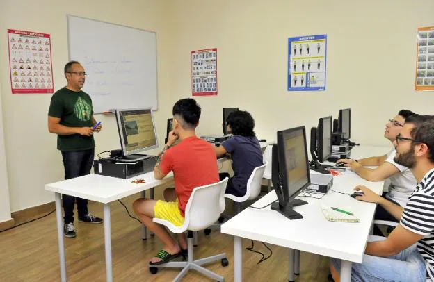 Un profesor imparte clase teórica en una autoescuela.