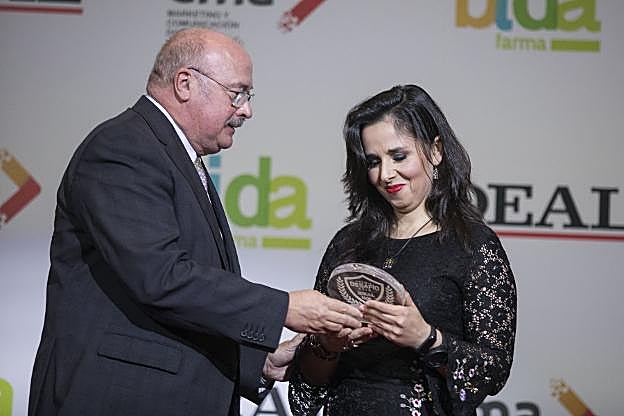 Michelle recibe el premio de manos de Eduardo Peralta.
