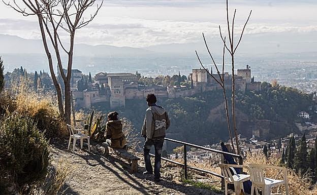 Dos moradores de las cuevas contemplan la belleza de las vistas sobre Granada.