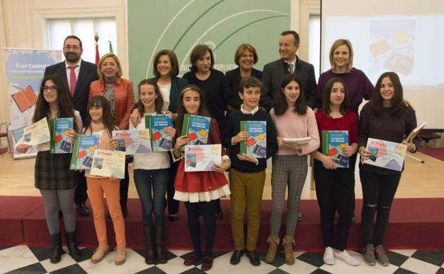 Los escolares premiados en las fases regional y provincial del certamen literario posan con sus diplomas junto a las autoridades. 