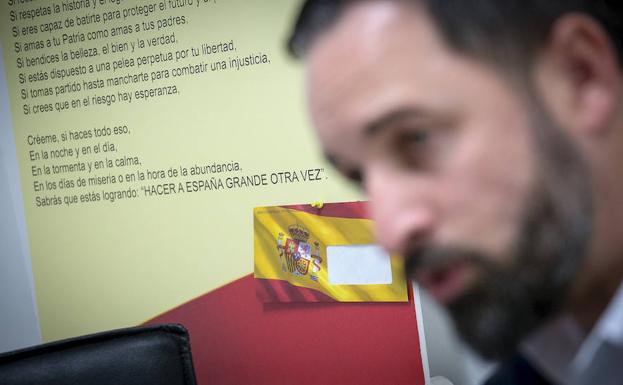 Santiago Abascal, junto a cartel en el que VOX llama a «hacer grande a España otra vez».