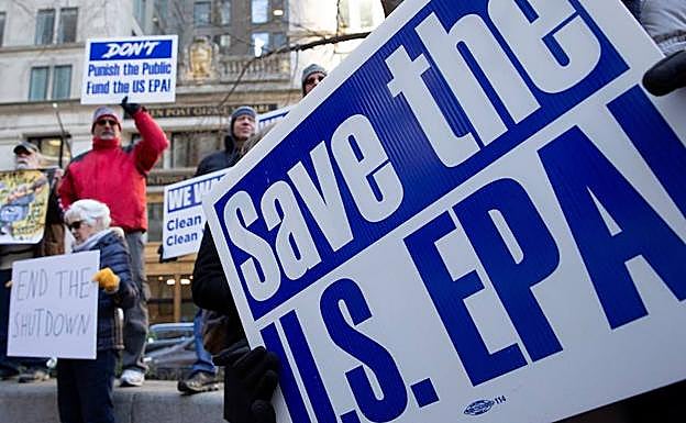 Varias personas protestan contra el cierre del gobierno en el exterior de una oficina de correos en Boston. 