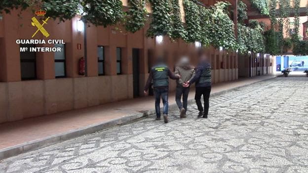 Agentes de la Guardia Civil conducen a uno de los detenidos a una dependencia de la Comandancia.
