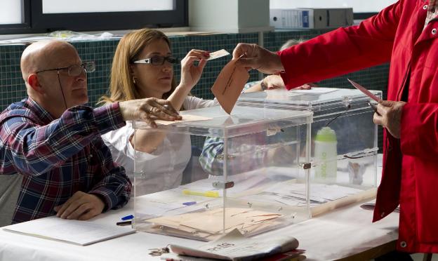 Un hombre introduce su voto en la urna en unas elecciones. 