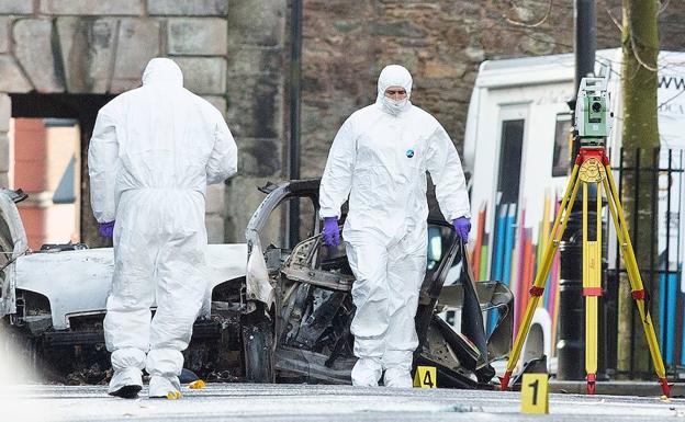 Efectivos policiales toman muestras del coche-bomba, en Londonderry.