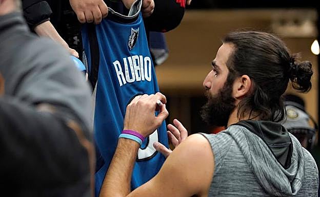 Ricky Rubio firma una camiseta. 
