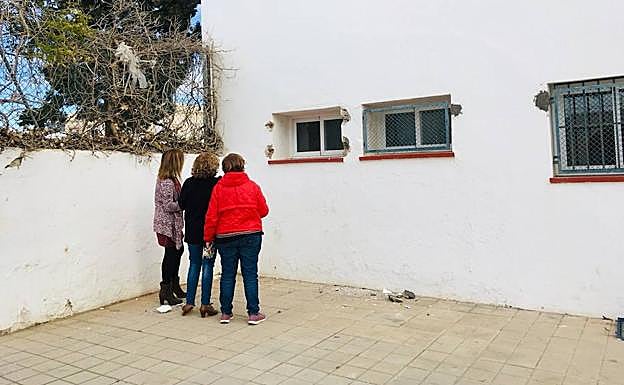 Un grupo de docentes observa la ventana por la que entraron los ladrones. 