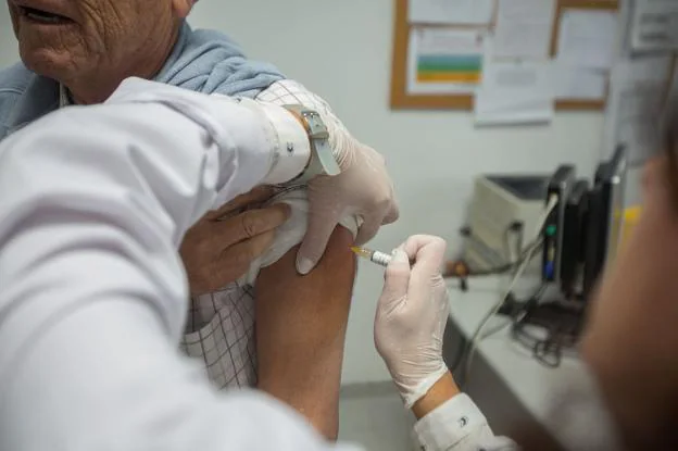 Personal sanitario vacuna contra la gripe en un centro de salud.
