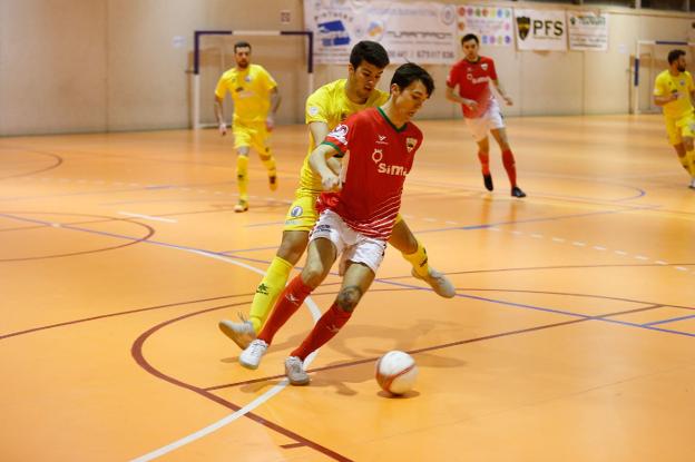 Un jugador del Sima protege el balón ante un rival.