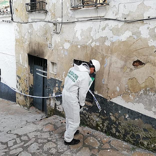 Un agente de criminalística de la Guardia Civil precinta la vivienda. 