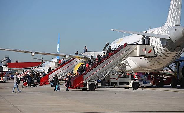 Pasajeros suben a un avión en la pista granadina