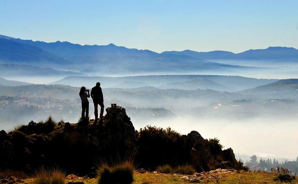 Una pareja contempla los efectos de la inversión térmica de las mañanas de febrero desde la ruta de la Alfaguara. 