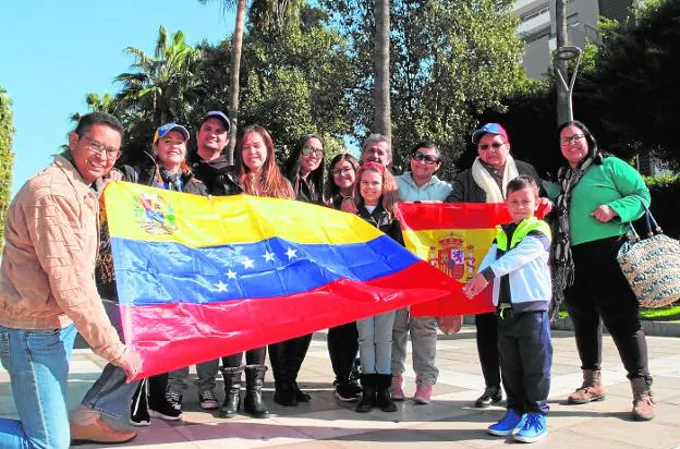 Varios miembros de la comunidad venezolana en Almería posan con la bandera de su país y otra de España «por gratitud a lo que nos dio», indica uno de ellos.