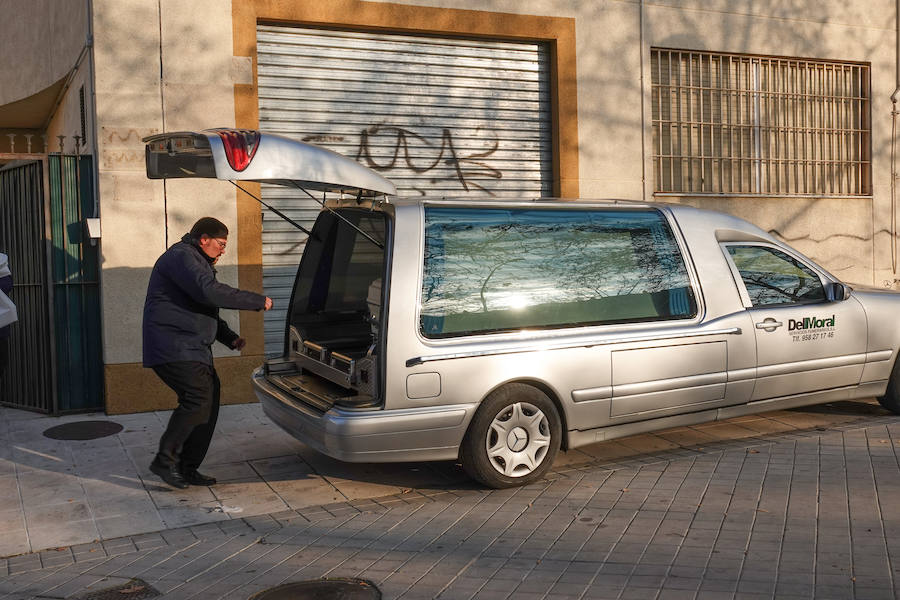 El servicio funerario introduce el féretro con los restos del bebé en el vehículo.