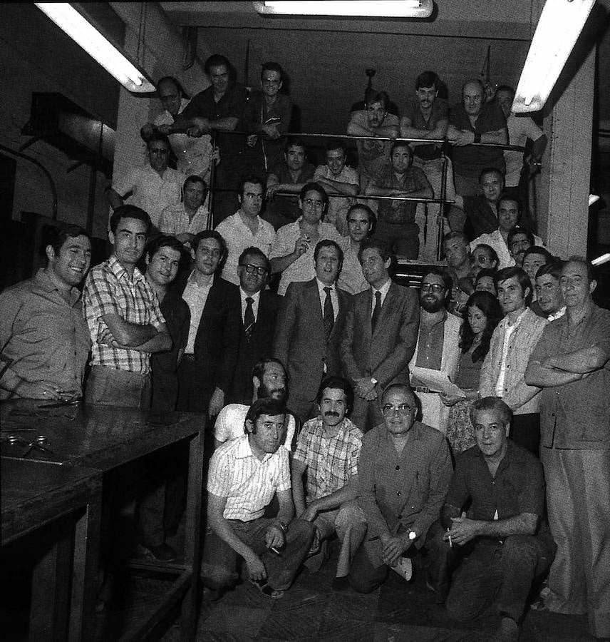 El presidente de la Junta, Rafael Escuredo, junto al director de IDEAL, Melchor Saiz Pardo, posan con los trabajadores de IDEAL en los talleres del periodico junto a la rotativa.