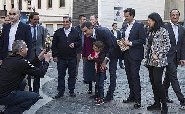 El presidente del Gobierno se hace una foto con una niña en la plaza de la Romanilla.