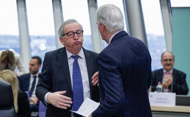 El presidente de la Comisión Europea, Jean-Claude Juncker (izq), conversa con el jefe negociador de la UE para el 'brexit' Michel Barnier (dcha)