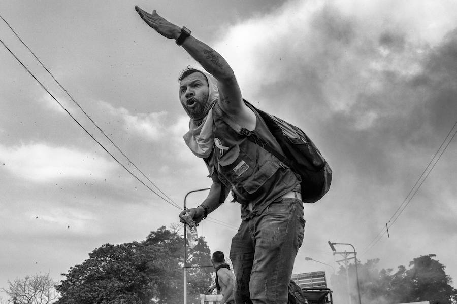 Cúcuta, Norte de Santander, Colombia: Un ciudadano venezolano insta a la población civil que acompañaba al convoy humanitario en el puente internacional Francisco de Paula Santander que se refugie para evitar los perdigones y los gases disparados por la Policía Nacional Bolivariana. 