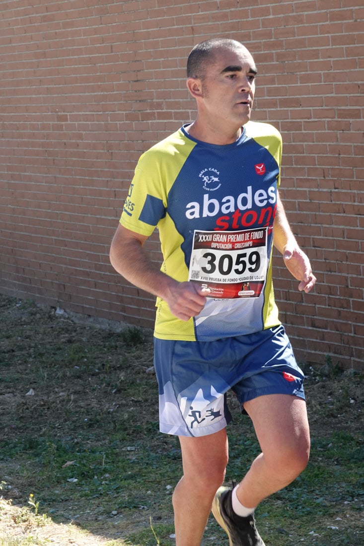 Manuel Santiago entra vistorioso a meta en la prueba de fondo de Loja. También lo hace victoriosa la más veterana de la cita. Y cientos de corredores desilan camino de la llegada al tartán.