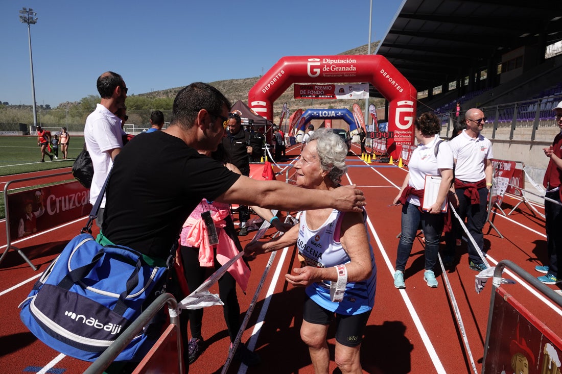 Manuel Santiago entra vistorioso a meta en la prueba de fondo de Loja. También lo hace victoriosa la más veterana de la cita. Y cientos de corredores desilan camino de la llegada al tartán.