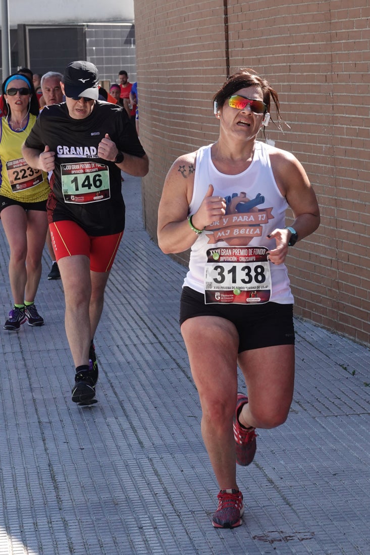 El reguero de atletas es amplio. Las piernas pesan en algunos momentos pero el objetivo de llegar a meta se mantiene. Si has participado en la carrera de fondo de Loja, prueba suerte a ver si te hemos retratado a lo largo del recorrido.