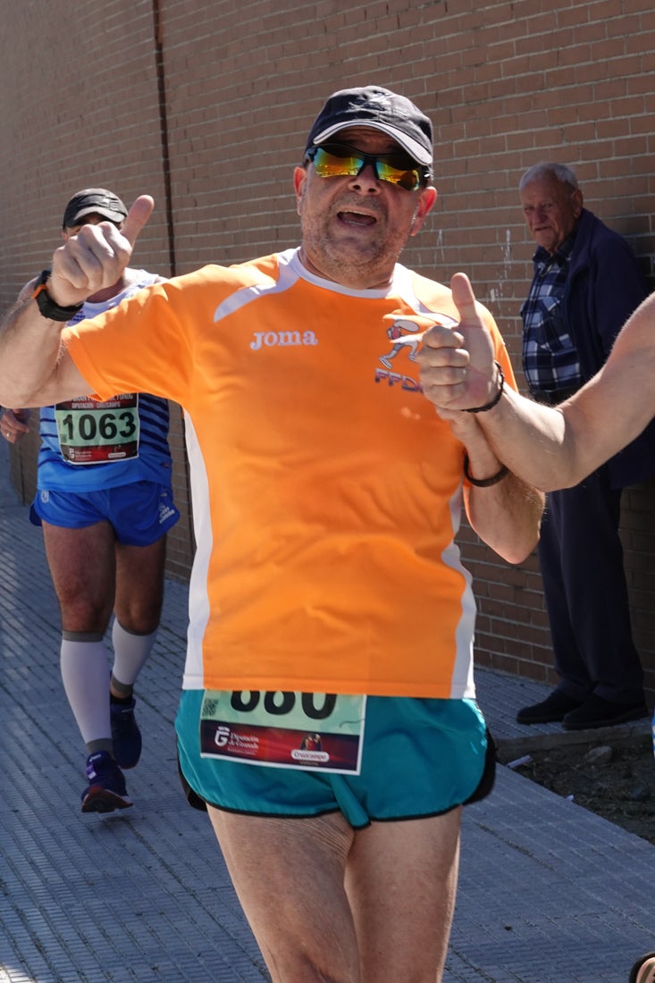 El reguero de atletas es amplio. Las piernas pesan en algunos momentos pero el objetivo de llegar a meta se mantiene. Si has participado en la carrera de fondo de Loja, prueba suerte a ver si te hemos retratado a lo largo del recorrido.