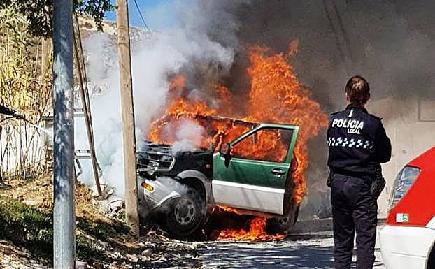 Un policía local de Baza observa el vehículo envuelto en llamas poco después de que las víctimas fuesen trasladadas al hospital.