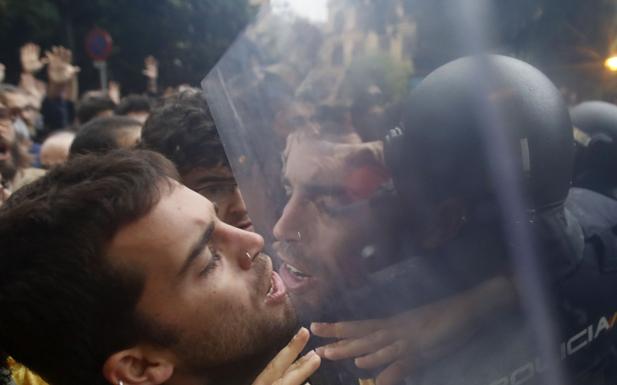 Manifestantes independentistas se enfrentan a un cordón de la Policía Nacional en el 1-O. 