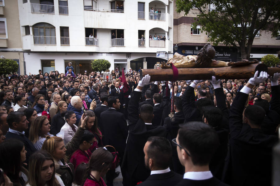 La imagen de Los Agustinos ha salido a la calle sobre las manos de los costaleros y rodeado de decenas de personas que le siguen con una vela encendida