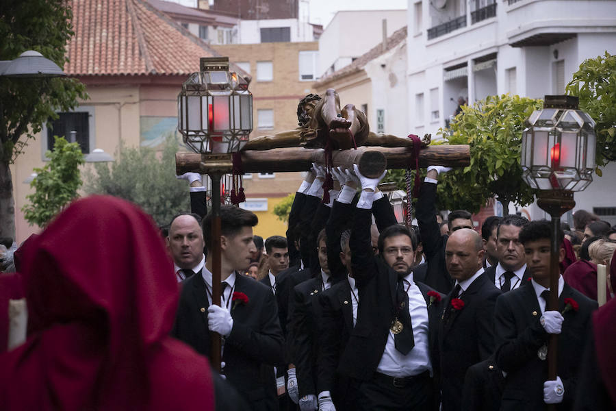 La imagen de Los Agustinos ha salido a la calle sobre las manos de los costaleros y rodeado de decenas de personas que le siguen con una vela encendida