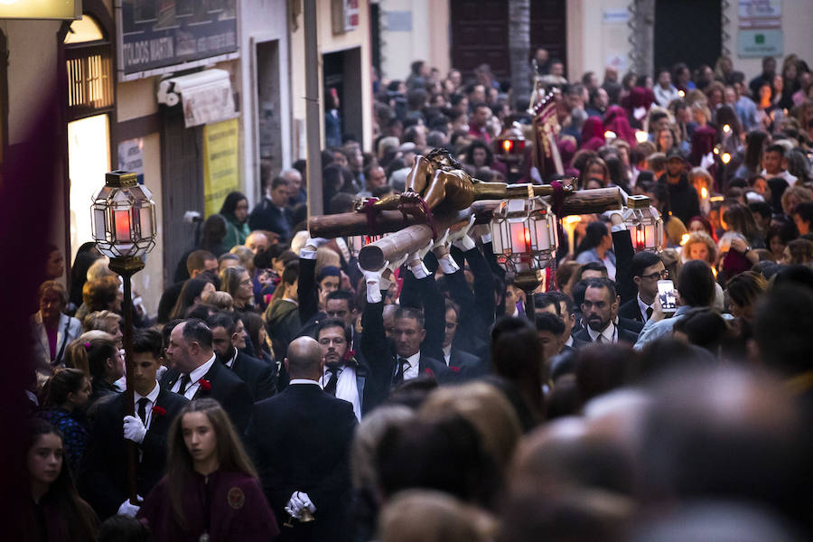 La imagen de Los Agustinos ha salido a la calle sobre las manos de los costaleros y rodeado de decenas de personas que le siguen con una vela encendida