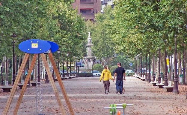 Dos jóvenes pasean por el paseo de la Bomba.