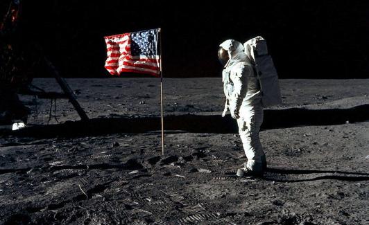 Edwin Aldrin junto a la bandera estadounidense durante su paseo lunar en 1957.