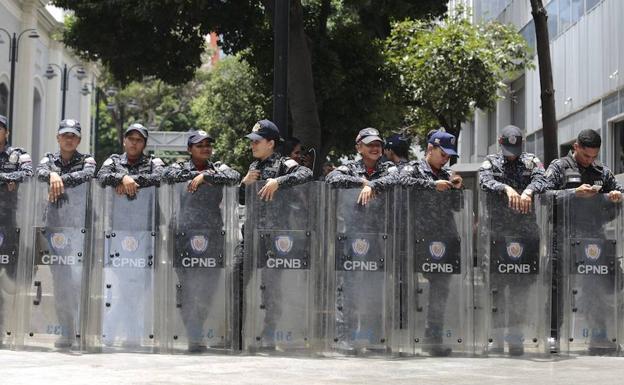 Varios policías esperan en una calle de Venezuela. 