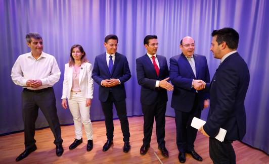 Los candidatos saludan al moderador antes del debate.