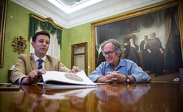 El alcalde Cuenca muestra el dossier fotográfico con las piezas donadas por José Manuel Brazam.