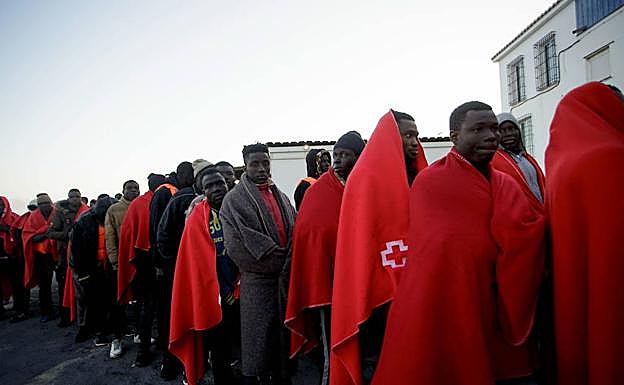 Un grupo de inmigrantes es atendido en el puerto de Motril tras ser rescatado de la patera en la que viajaban