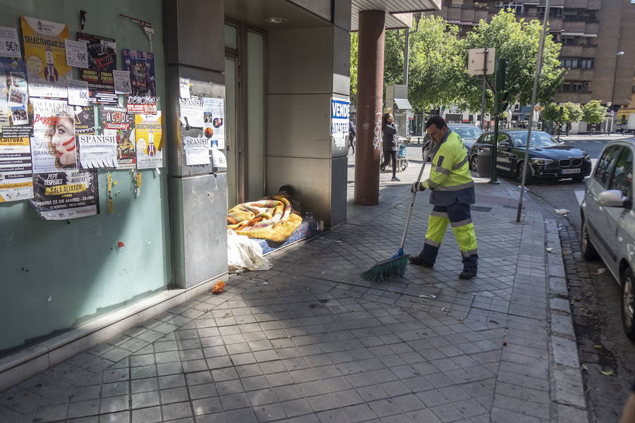 Una persona sin hogar duerme en la puerta de un establecimiento cerrado en Granada.