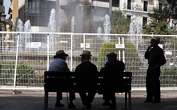 Cuatro ancianos charlan en un banco