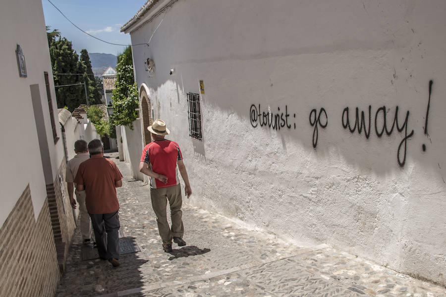 Los grafitis animan a los visitantes a marcharse de la ciudad y les acusan de desvirtuar la esencia del barrio granadino