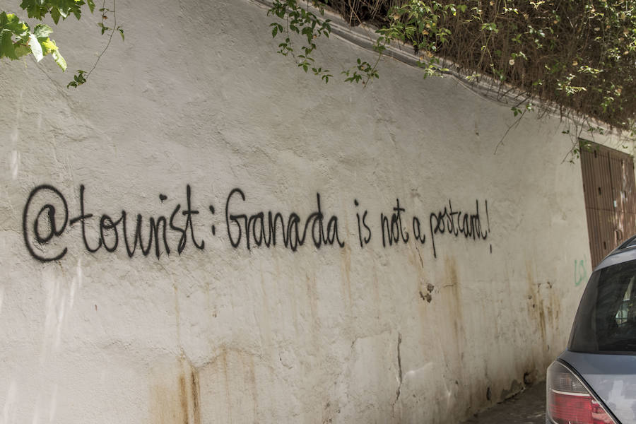 Los grafitis animan a los visitantes a marcharse de la ciudad y les acusan de desvirtuar la esencia del barrio granadino