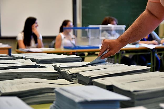 Un votante coge una papeleta en un colegio electoral de Almería.
