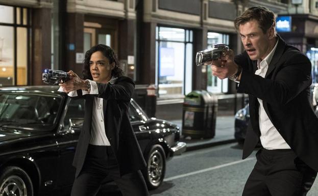 Tessa Thompson y Chris Hemsworth vestidos de negro.