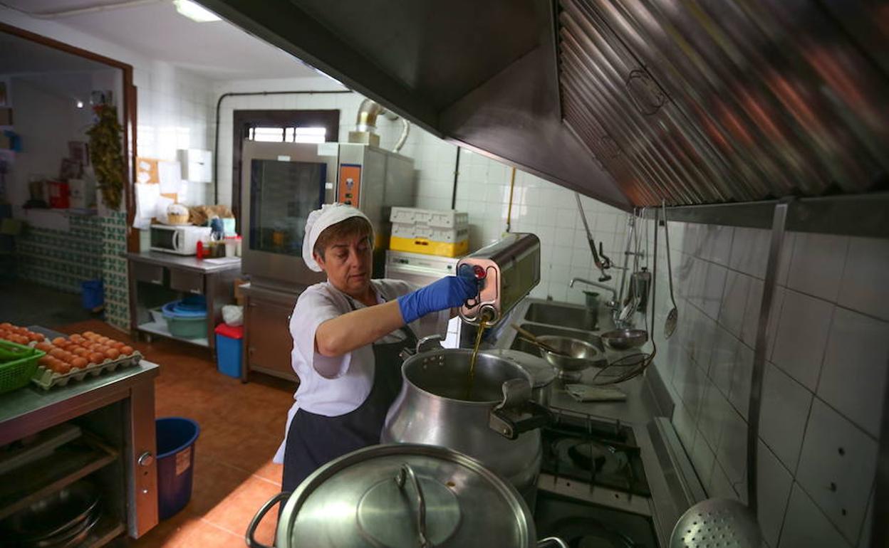 Una mujer trabajando en unas cocinas escolares.