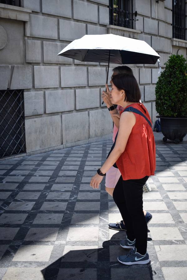 Granadinos y visitantes se las apañan en las calles para no sufrir mucho el enorme calor de estos días