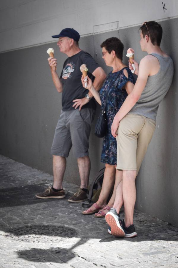 Granadinos y visitantes se las apañan en las calles para no sufrir mucho el enorme calor de estos días