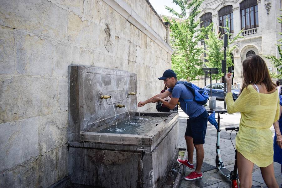 Granadinos y visitantes se las apañan en las calles para no sufrir mucho el enorme calor de estos días