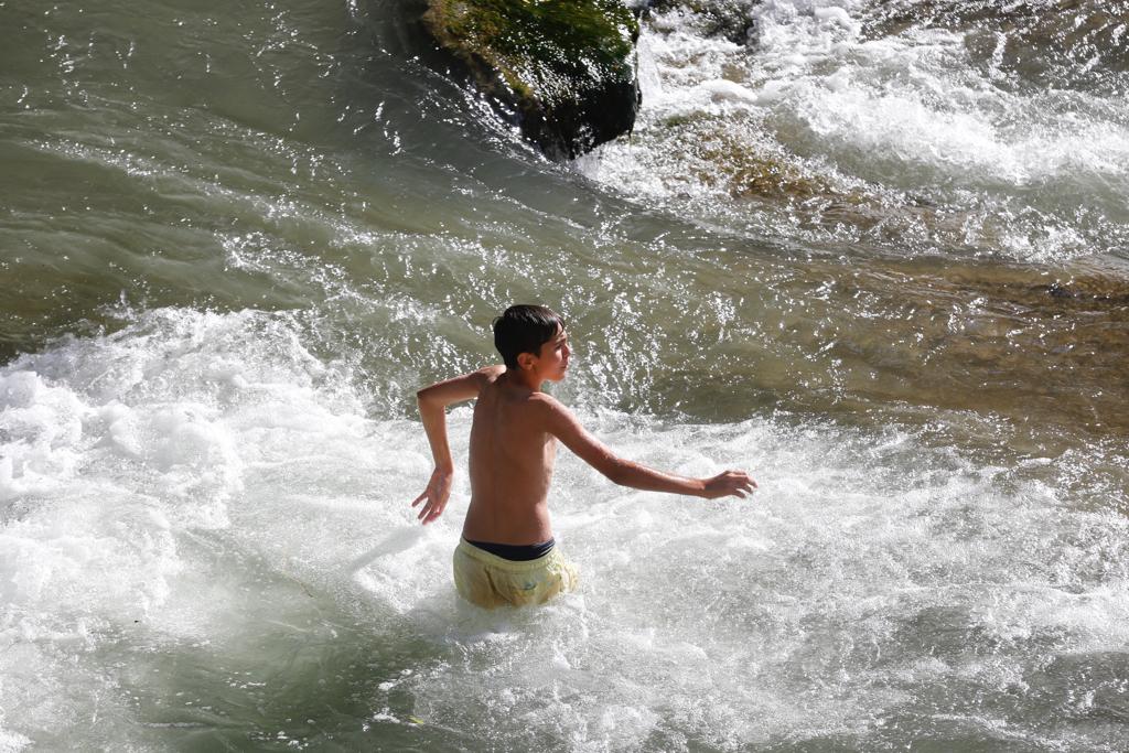 Granadinos y visitantes se las apañan en las calles para no sufrir mucho el enorme calor de estos días